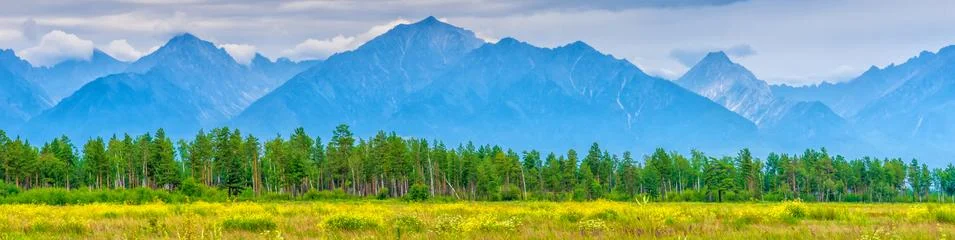 Panoramic summer landscape of mountain range with peaks, valley with green gr Stock Photos