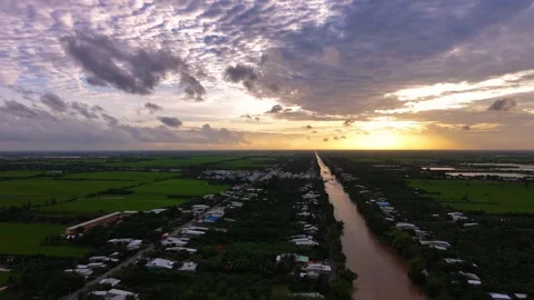 Panoramic sunset aerial view over a straight canal and green fields Stock Footage 344838651