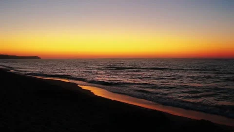 Panoramic Sunset Over Sandy Beach with Gentle Sea Waves and Golden Sky 스톡 동영상 331834697