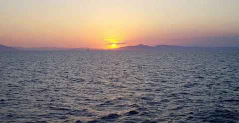 Panoramic sunset with sun peeking through clouds over choppy seas￼￼ 스톡 동영상 202254818