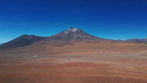 Panoramic tilt up from vast red arid altiplano desert floor to dramatic Stock Footage 336265911