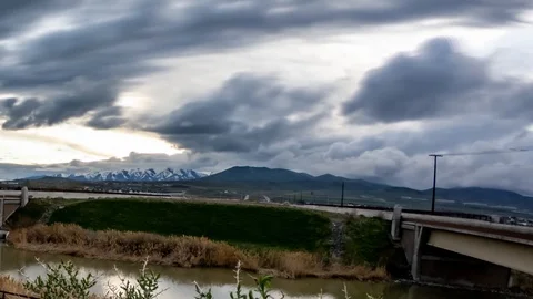 Panoramic time lapse of a dramatic cloudscape above a highway and mountain range Stock Footage 106789213