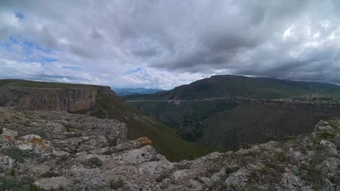 Panoramic time lapse of dramatic mountain landscape with shifting clouds ov.. Stockbeeldmateriaal 337763262