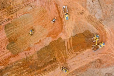 Panoramic top view of work backhoe digging soil and loads a dump truck with e Stock Photos