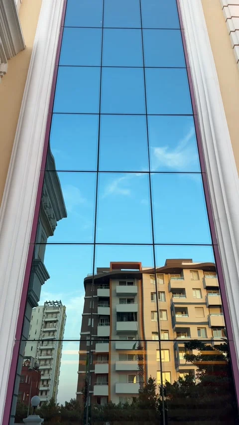 A panoramic upward view of a massive mirrored wall or window reflecting the s Video stock 301863934