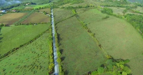 Panoramic view from above on a forest road, fields and forest, a building in the Stock Footage 73606082
