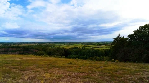 Panoramic view across rolling countryside under dramatic cloudy sky. Green Vídeo Stock 338069147