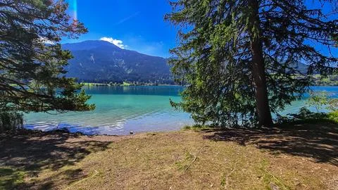 Panoramic view of alpine landscape seen from east bank of lake Weissensee i.. Stock Photos