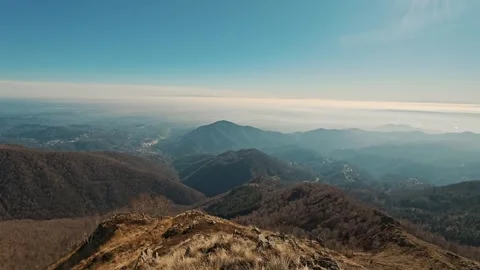 Panoramic view from alpine summit of misty valley with Italian towns and large Stock Footage 324929815