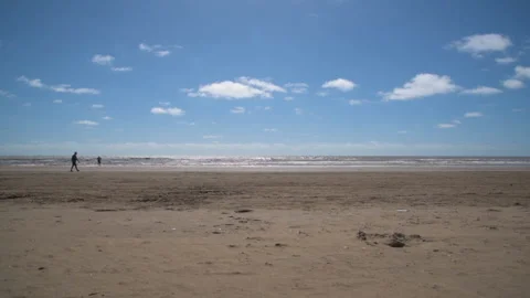 Panoramic view of an argentinian beach with people passing by at the back Stock Footage 150347822