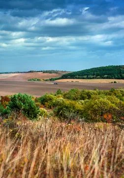 Panoramic view of the autumn plowed fields with work tractors from the height Stock Photos