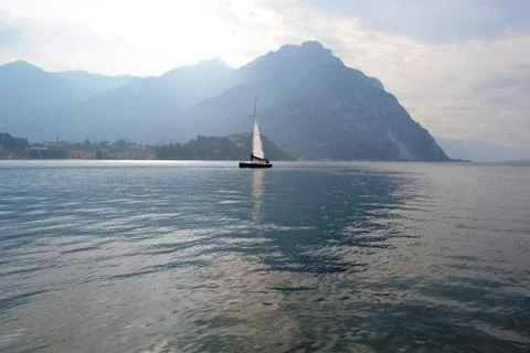 Panoramic view in backlit to the lake Como at Lecco with sailboat. Stock Photos