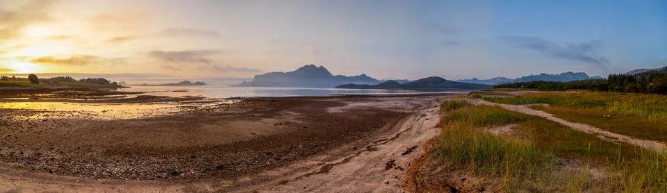 Panoramic view from beach of the setting sun on Amnesvika bay with mountains  Stock Photos