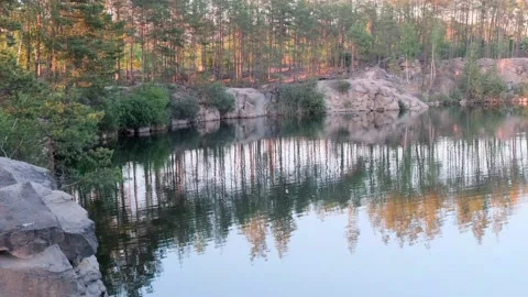 Panoramic view of a beautiful clear lake among granite rocks and pine forest Vídeo Stock 145496156
