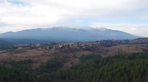 Panoramic view of the big mountain snowy peak and a small village Aerial Stock Footage 58254272