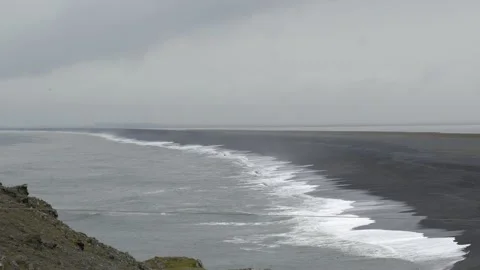Panoramic view of a black sand beach with crashing waves in Iceland 4K footage Stock Footage 339925320