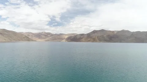 Panoramic View of Blue Alpine Lake and Brown Rugged Mountains Vídeos de archivo 332580250