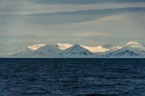 Panoramic view of Blue hour of the mountains, snow and Sea in Svalbard, Norway. Stock Photos