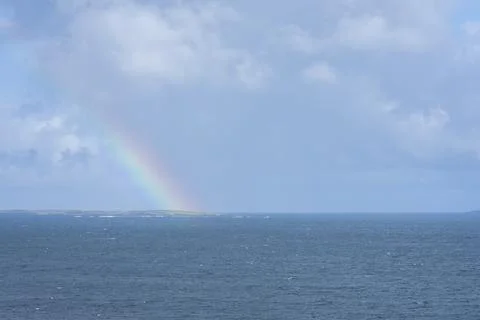 A panoramic view with blue sky with clouds and a rainbow. Stock Photos