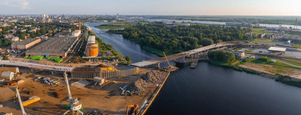 Panoramic View of Bridge Construction and Riga Skyline at Golden Hour 写真素材