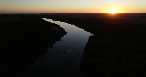 Panoramic view of calm river at sunset with boat sailing at tranquil surface 스톡 동영상 119084750