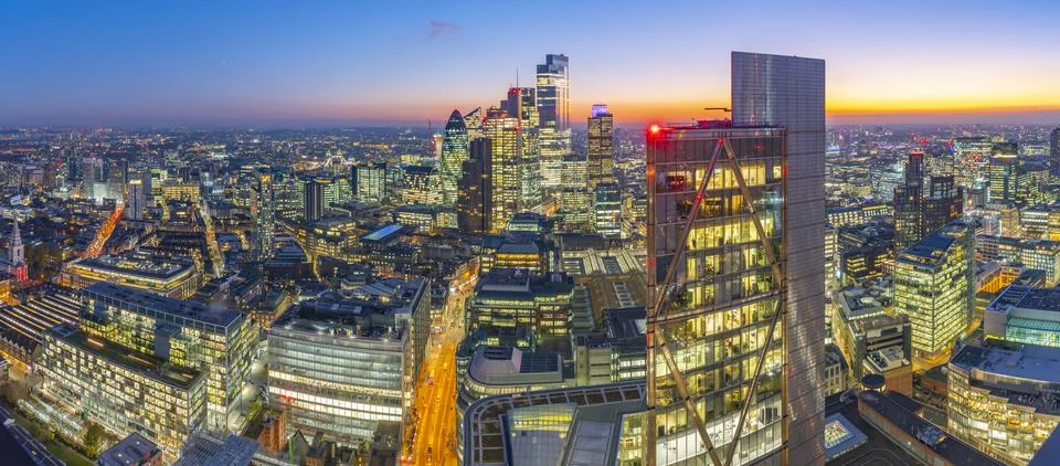 Panoramic view of City of London skyscrapers and Tower Bridge at dusk from the Stock Photos