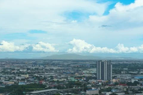 Panoramic view of cityscape under cloudy sky, showcasing buildings and greene Stock Photos