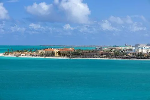 Panoramic view of clear blue ocean water and a sandy beach lined with beachfront Stock Photos