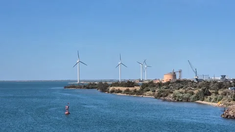 Panoramic view of a coastal industrial area featuring wind turbines Vídeos de archivo 335044448