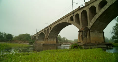 Panoramic View of Concrete Bridge on Grassy Riverbank in Italy DCI 4K Stock Footage 202291901