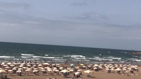 Panoramic View of Crowded Beach with Umbrellas and Blue Sea Video stock 328683900