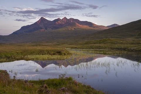 Panoramic view of Cuillin mountain range reflected in calm water Stock Photos