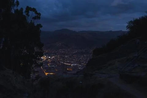 Panoramic view of Cusco town with glowing city lights at dusk. Cusco is among Stock Photos