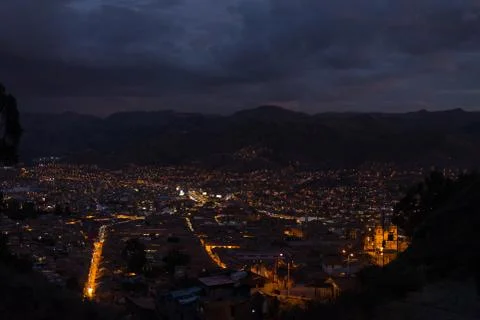 Panoramic view of Cusco town with glowing city lights at dusk. Cusco is among Stock Photos
