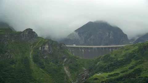 Panoramic view of a dam high in the mountains with fog and clouds Vidéo 122062785