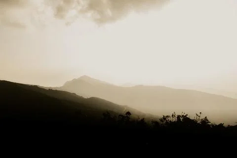 Panoramic view of dark mountains covered with mist in the forest of western.. Stock Photos
