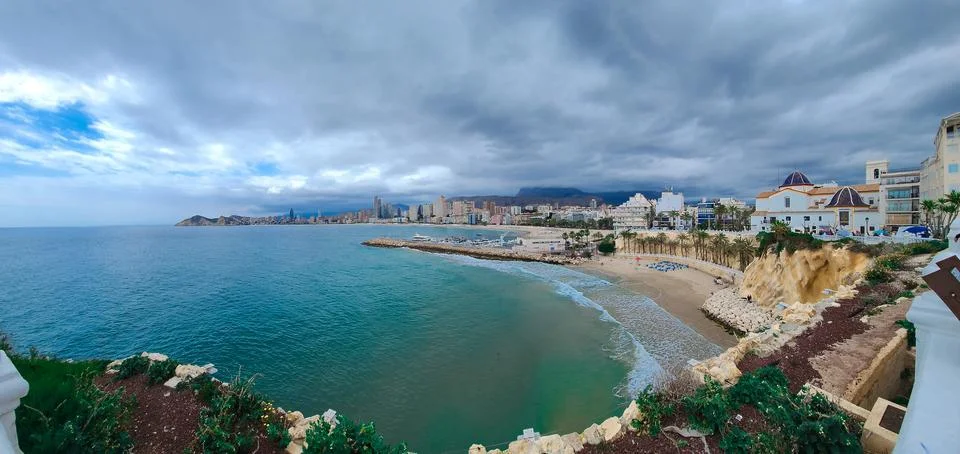 Panoramic view of dramatic cloudy sky over Benidorm tourist city and beach Stock Photos