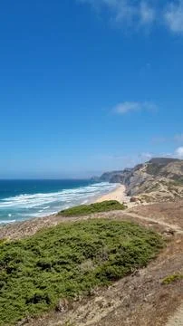 Panoramic view of dramatic coastal cliffs, sandy beach, and turquoise Atlanti Stock Photos