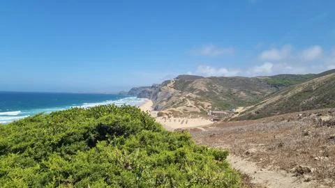 Panoramic view of dramatic coastal cliffs, sandy beach, and turquoise Atlanti Stock Photos