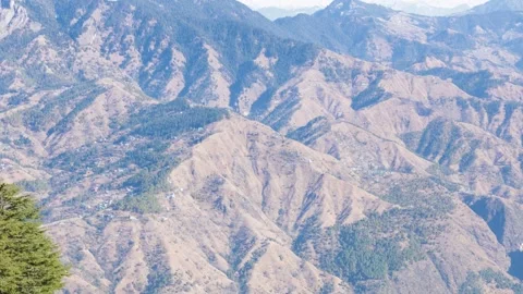 Panoramic view of dry mountain terrain with green forest patches Stock Footage 328706473