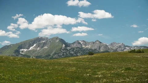 Panoramic view of the Durmitor mountain range rising above alpine meadows in Vídeo Stock 342402541