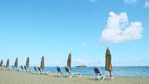 Panoramic view at empty golden ocean shore with beach chairs and closed Video stock 130485057