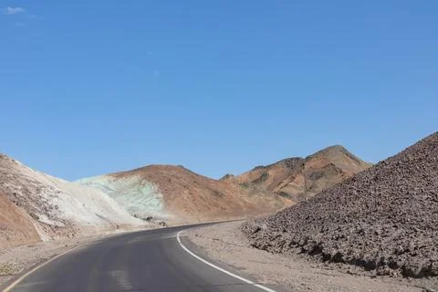 Panoramic view of endless empty road leading to colorful geology of multi h.. Stock Photos