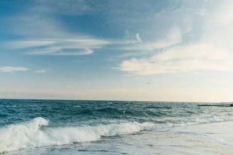 Panoramic view of evening sea with empty beach and waves Stock Photos