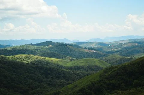 Panoramic View of Forested Mountain Range with Layered Green Hills and Blue Sky Stock Photos