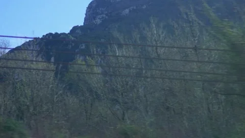 A panoramic view of forested mountains and rocky peaks from a train Stock-Footage 328930299