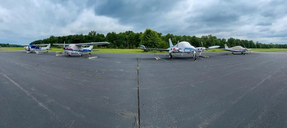 Panoramic view of four small private airplanes on tarmac. Stock Photos