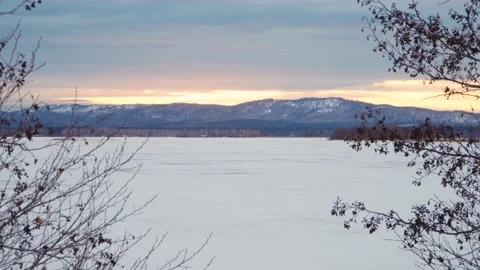 Panoramic view of the frozen lake through the branches of trees. Video stock 236555698