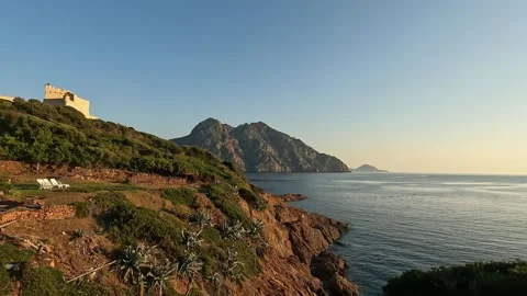 Panoramic view of girolata castle and deckchairs facing sea. corsica 動画素材 277541229