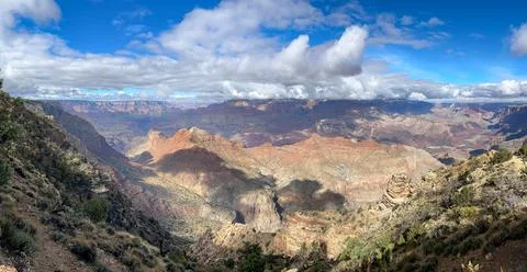 Panoramic View of the Grand Canyon with Dramatic Clouds and Sunlit Rock Formatio Foto stock